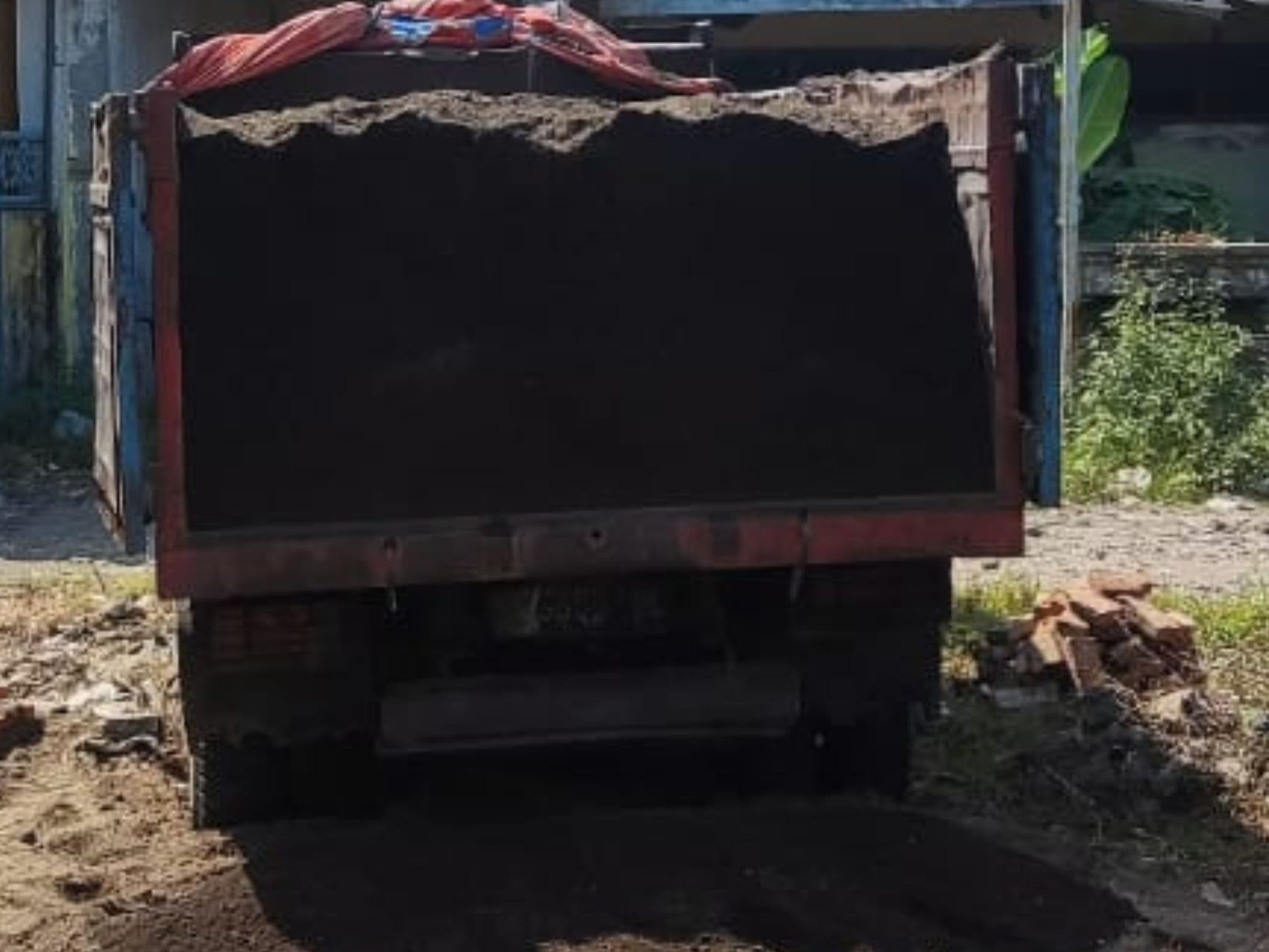 Dump truck menumpahkan tanah urug di lahan proyek UMKM 34